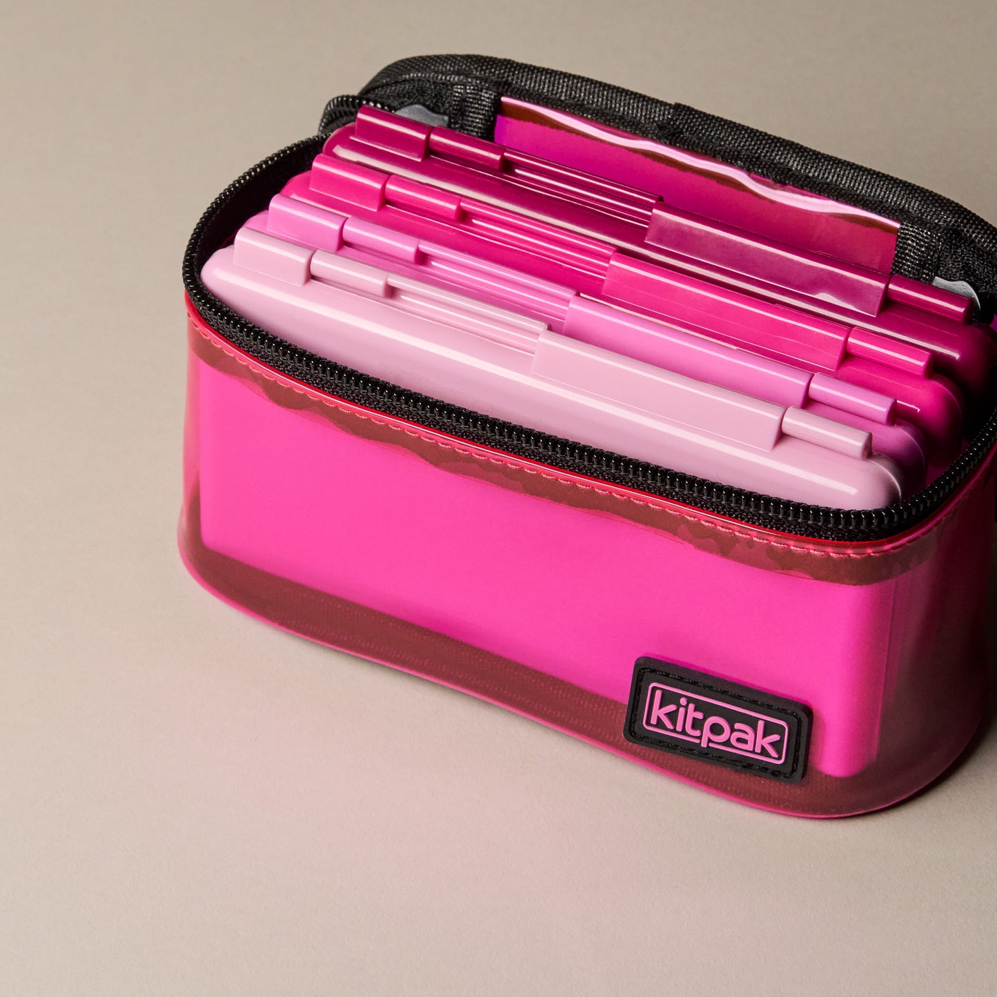 Small magnetic palettes for depotted makeup in four shades of pink with a matching bag.